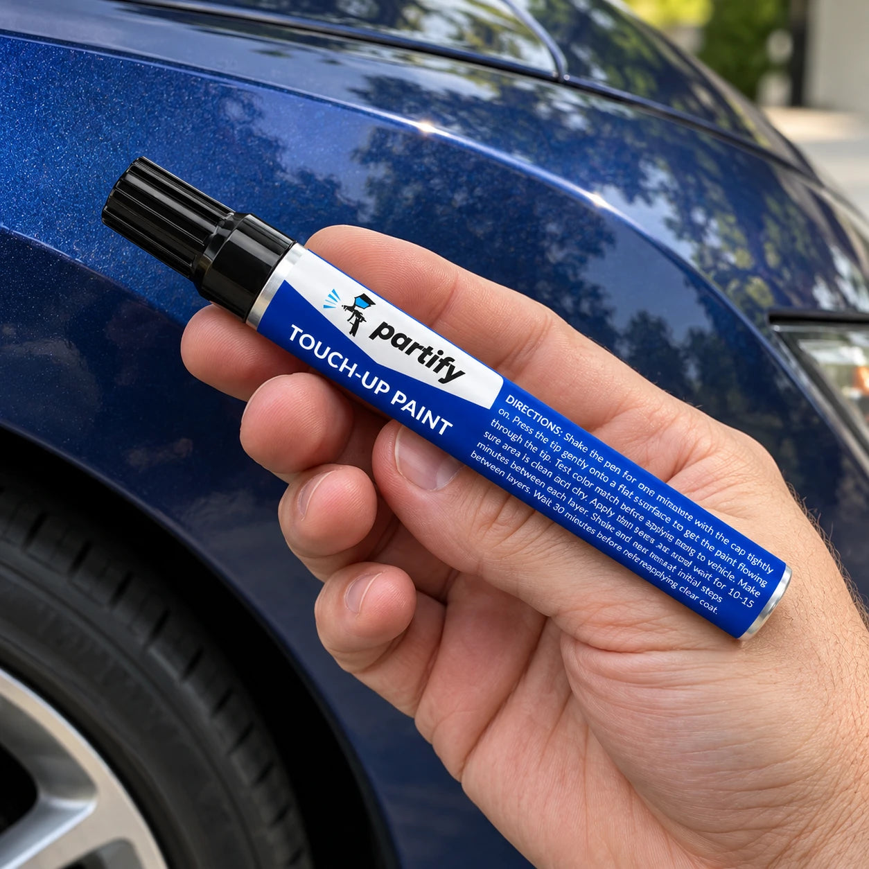 Current black-capped Partify paint pen held in a hand for scale