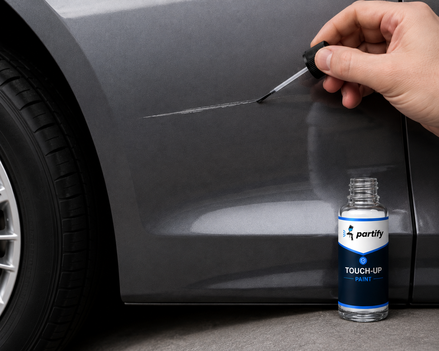 Applying Partify touch-up paint with a precision brush to a scratch on a dark vehicle